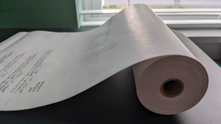 A photo of a roll of fax paper with some printing on it, showing its smooth texture.